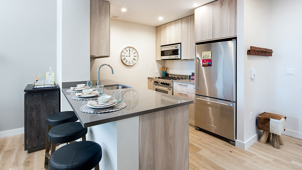 Modern Kitchen with Stainless Steel Appliances, Large Fridge and Eating Counter with Bar Stools